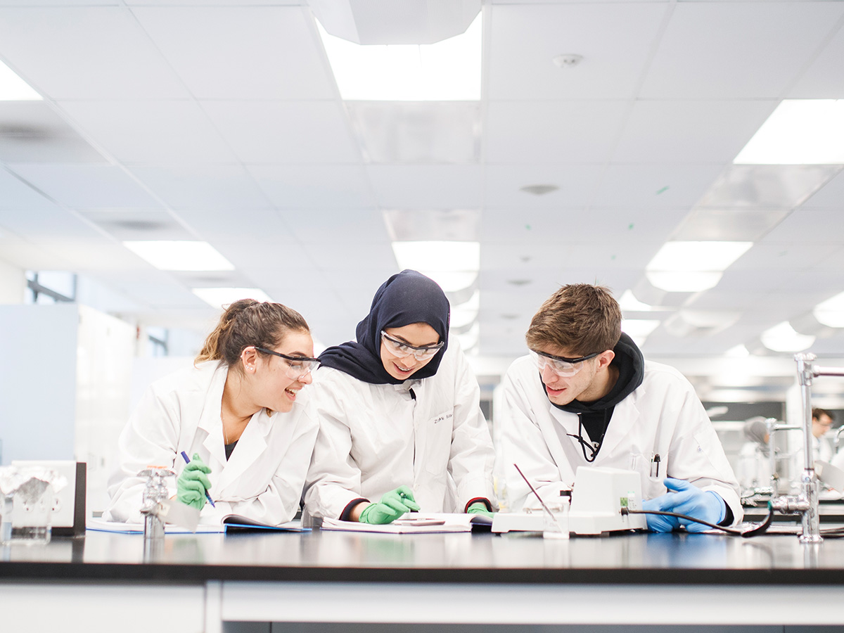 Three students collaborating in a lab