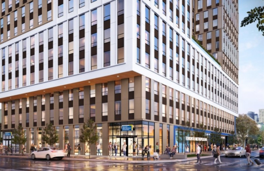 Modern multi-storey building on a city street corner with people walking and cars passing by.