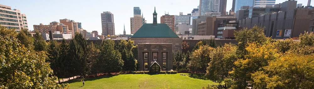 View of the TMU Quad and clock tower with the city skyline in the background. 