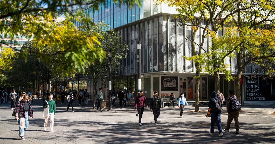 Students walking on Gould street by the Image Arts building on a sunny day.
