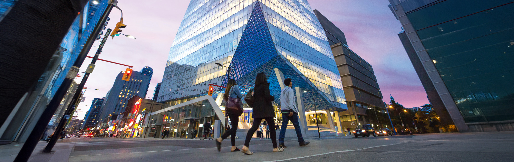 Students walking across the street to the Student Learning Centre (SLC) on campus in the evening. 