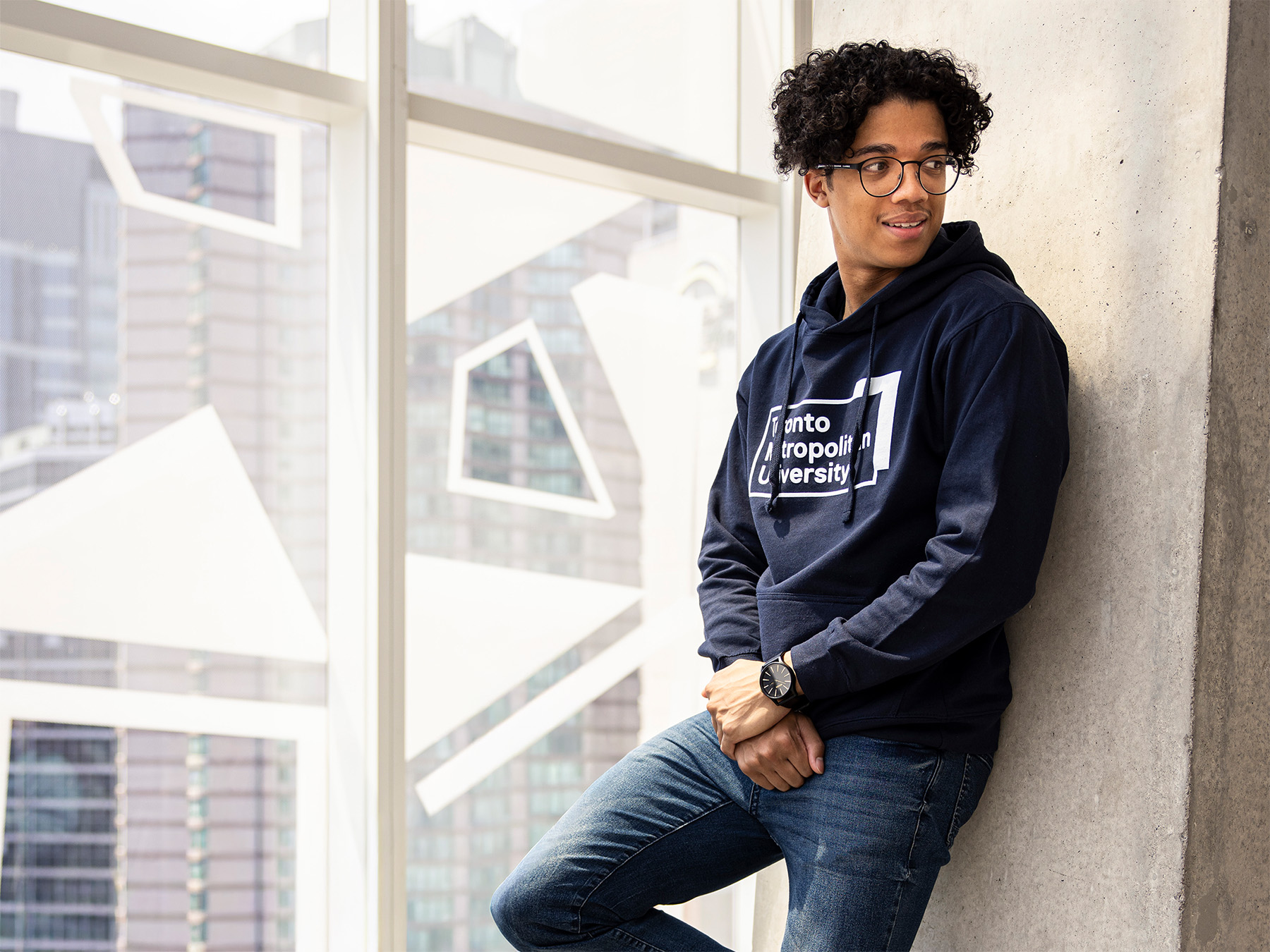 Student wearing a Toronto Metropolitan University (TMU) hoodie at the Student Learning Centre (SLC).