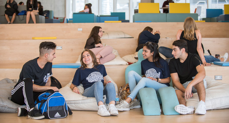 Students laugh together while lounging on the bean bag chairs in the SLC.