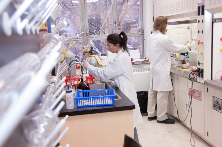 Students working inside a lab with lab coats
