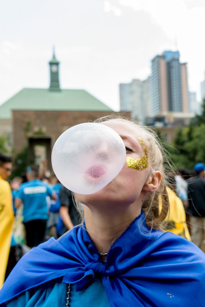 Student from Orientation week blowing a bubble with bubble gum in the Quad