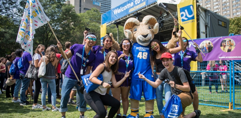 Eggy mascot posing with students on Orientation Week