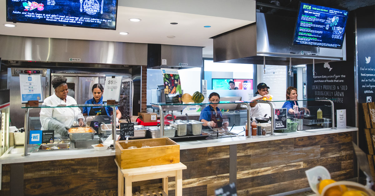 Cafteria staff behind the counter waiting to serve people