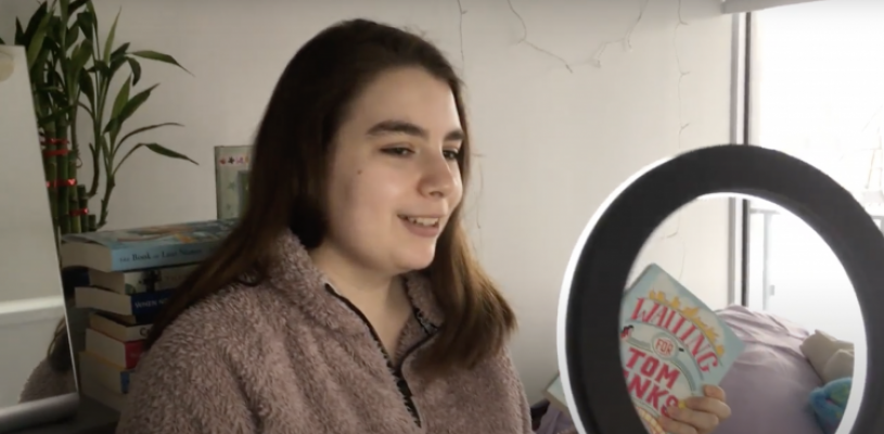 Jenna in front of her laptop and beauty light for a promotional video she is making