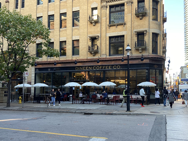 Dineen Coffee Co is seen from across the street with its umbrella-lined patio 