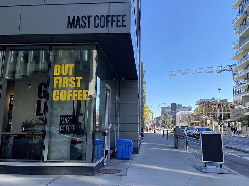 Mast Coffee's window displays big block yellow letters that read "But first, coffee."