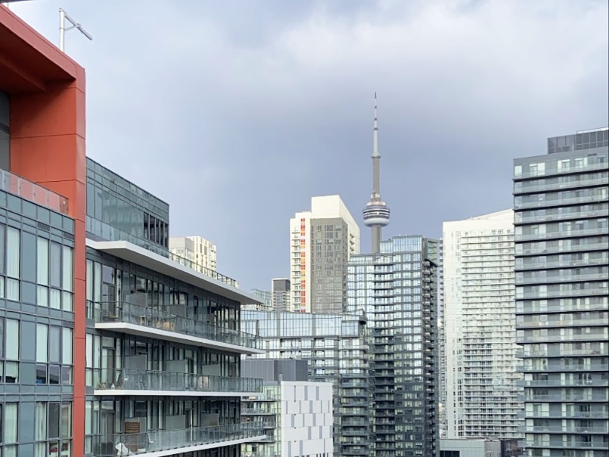 A view of several high rise condo buildings is seen with the CN tower visible as well.