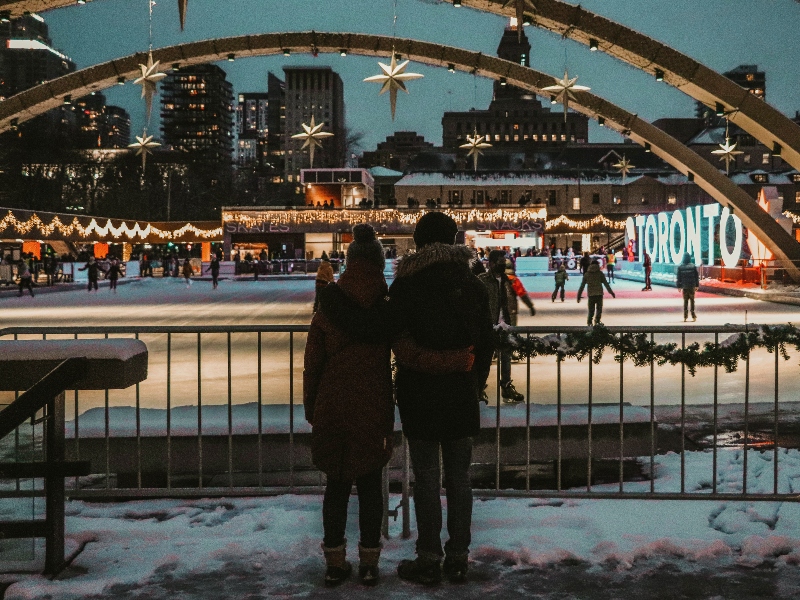 Two people standing by Toronto City Hall skating rink