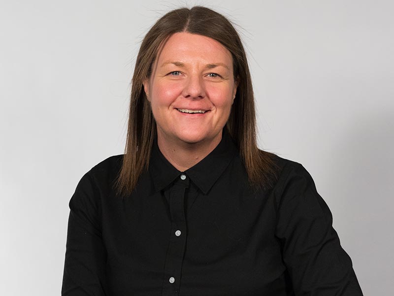 Creative Industries Manager of Academic Advising Paula Rayson smiles in front of a white background.