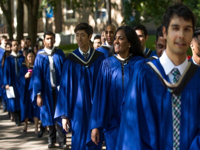 Group of student graduates with their gowns walking 