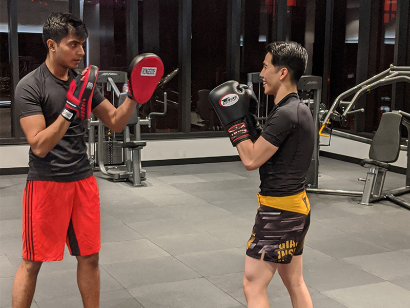 Jeremy preparing to punch the focus mitts being held in front of him by his friend