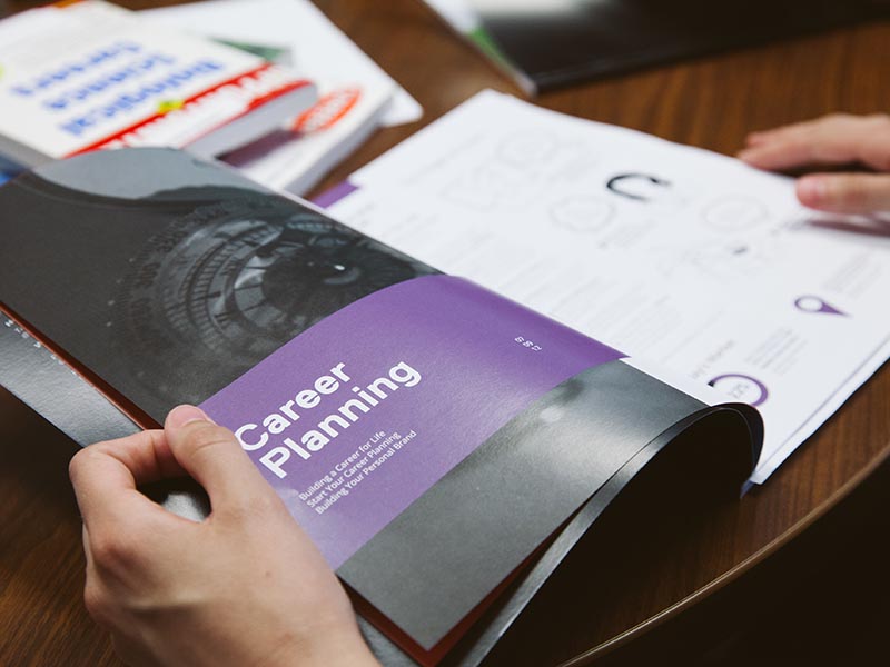 A student looks at an article about career planning in a booklet.