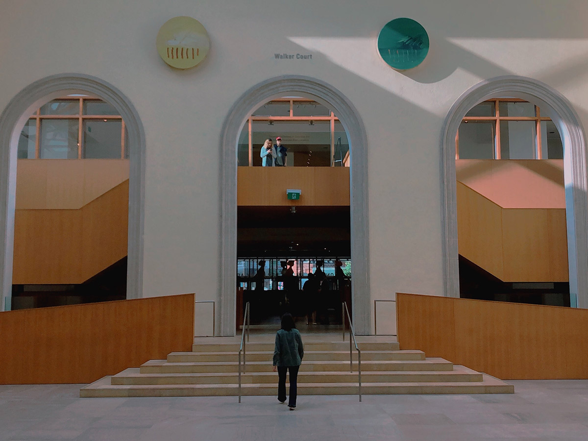 A visitor walks up a set of stairs inside the Art Gallery of Ontario.
