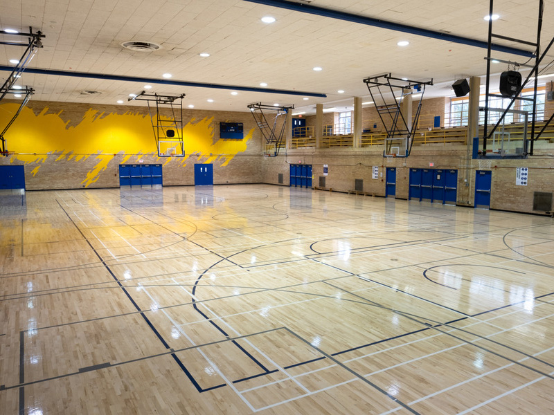 Inside the gym of the Kerr Hall Upper West Gym with all the basketball nets mounted on the ceiling rolled down.