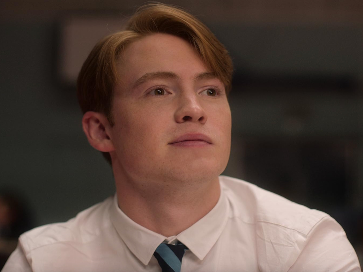 Nick looks into the distance with a smirk
