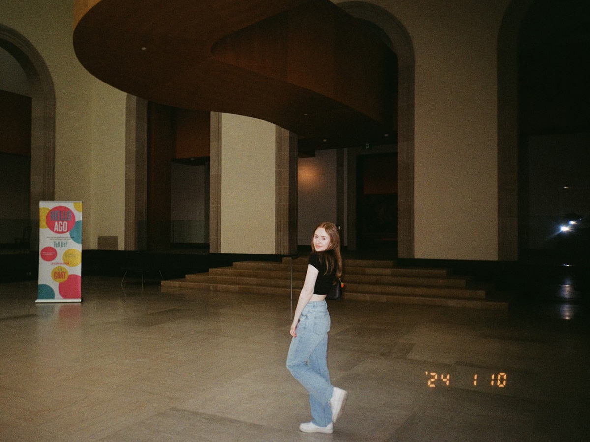 Claire smiling and posing for the camera inside of the AGO. 