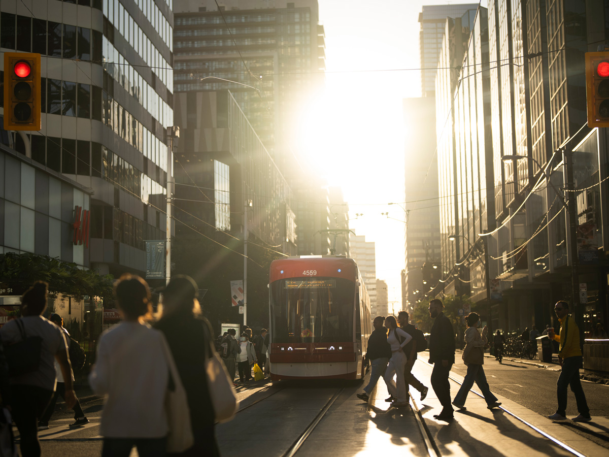 Crowds walking along Yonge and Dundas at sunset.