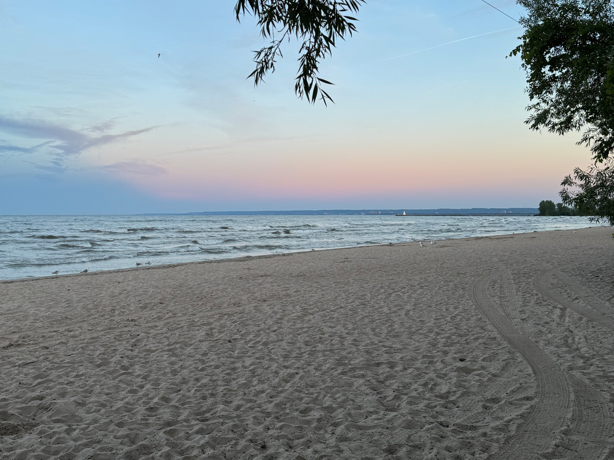 A landscape view of an empty beach at sunset.