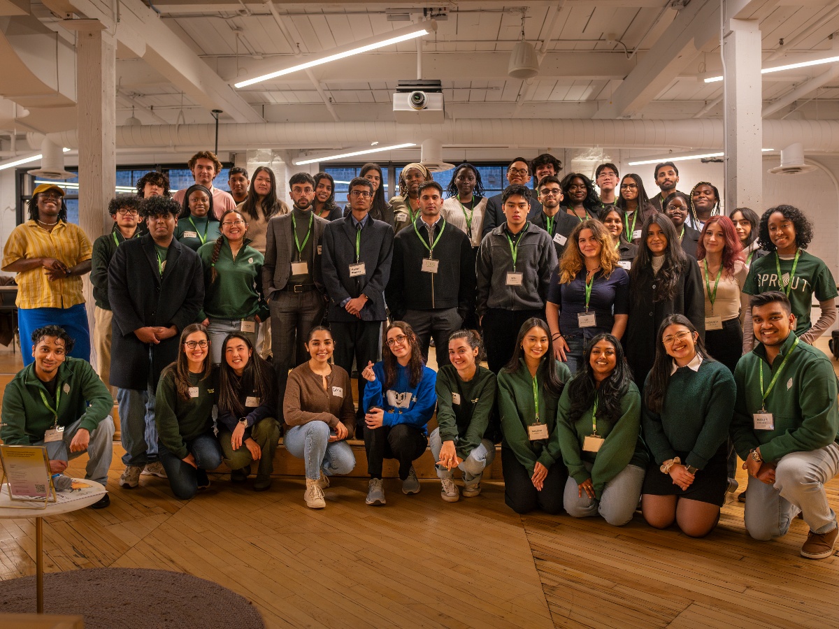 A bunch of members from the SPROUT team smile in green uniform.
