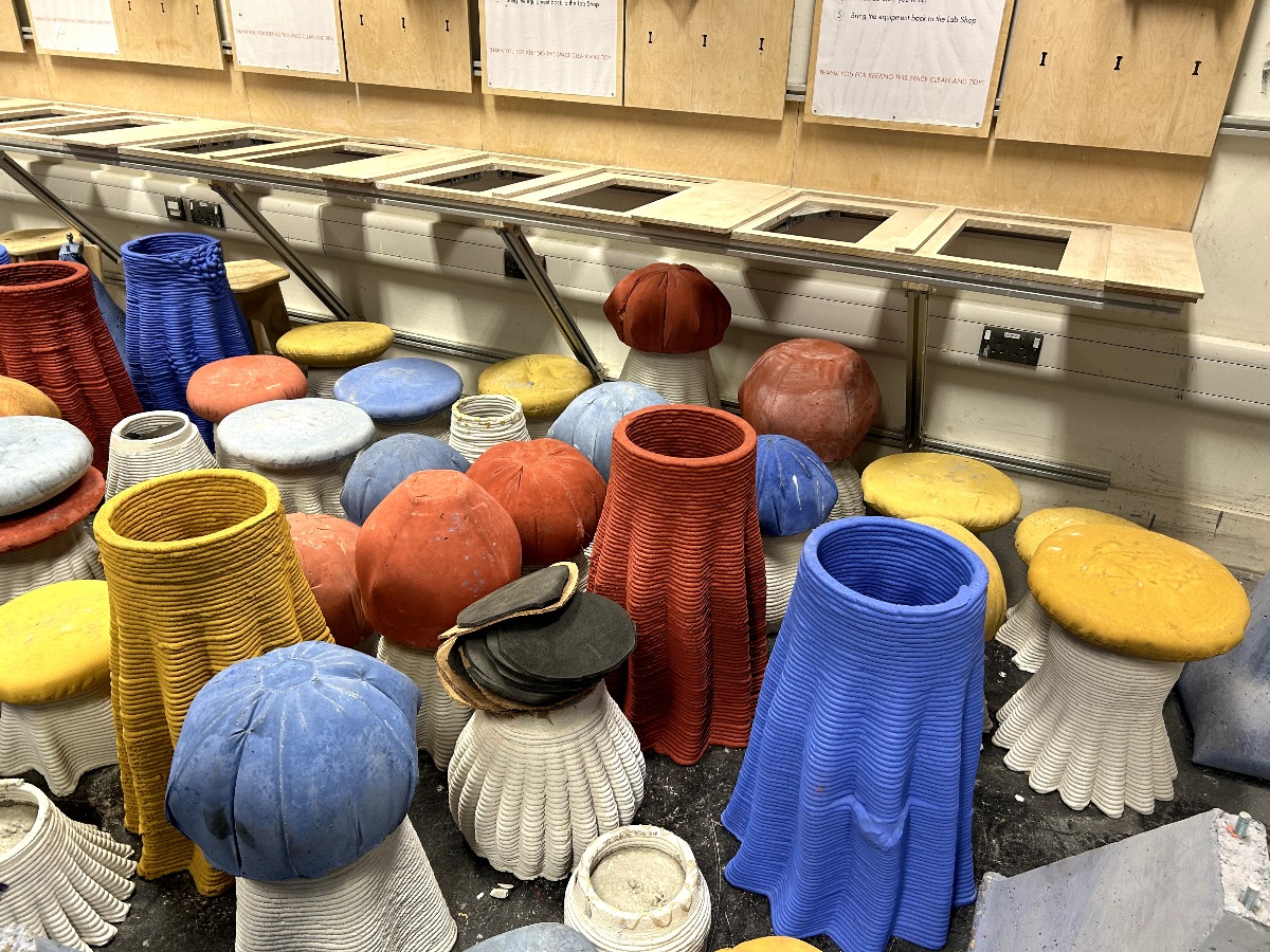 Stool-like sculptures scattered across the floor in playful shapes and colours. 