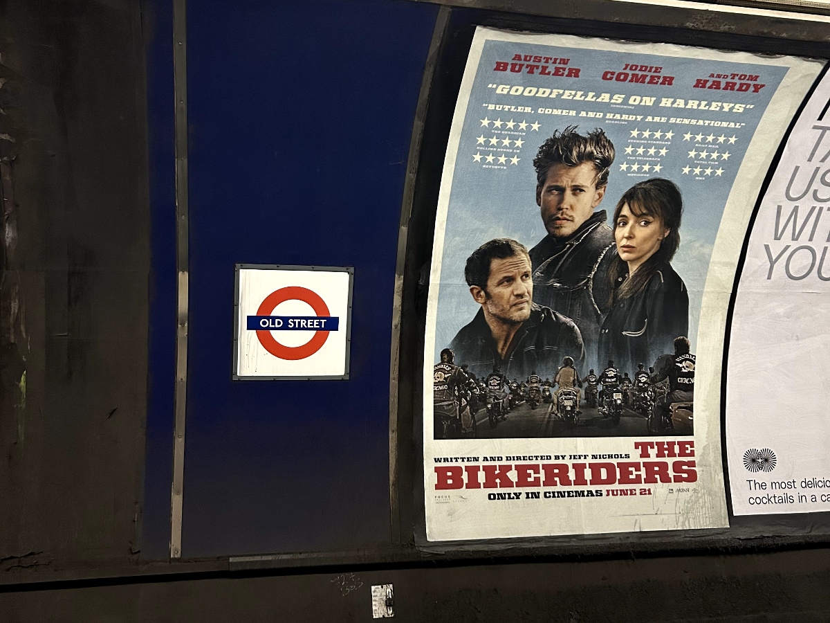 An advertisement for "The Bikeriders" film is plastered onto the wall in Old Street station.