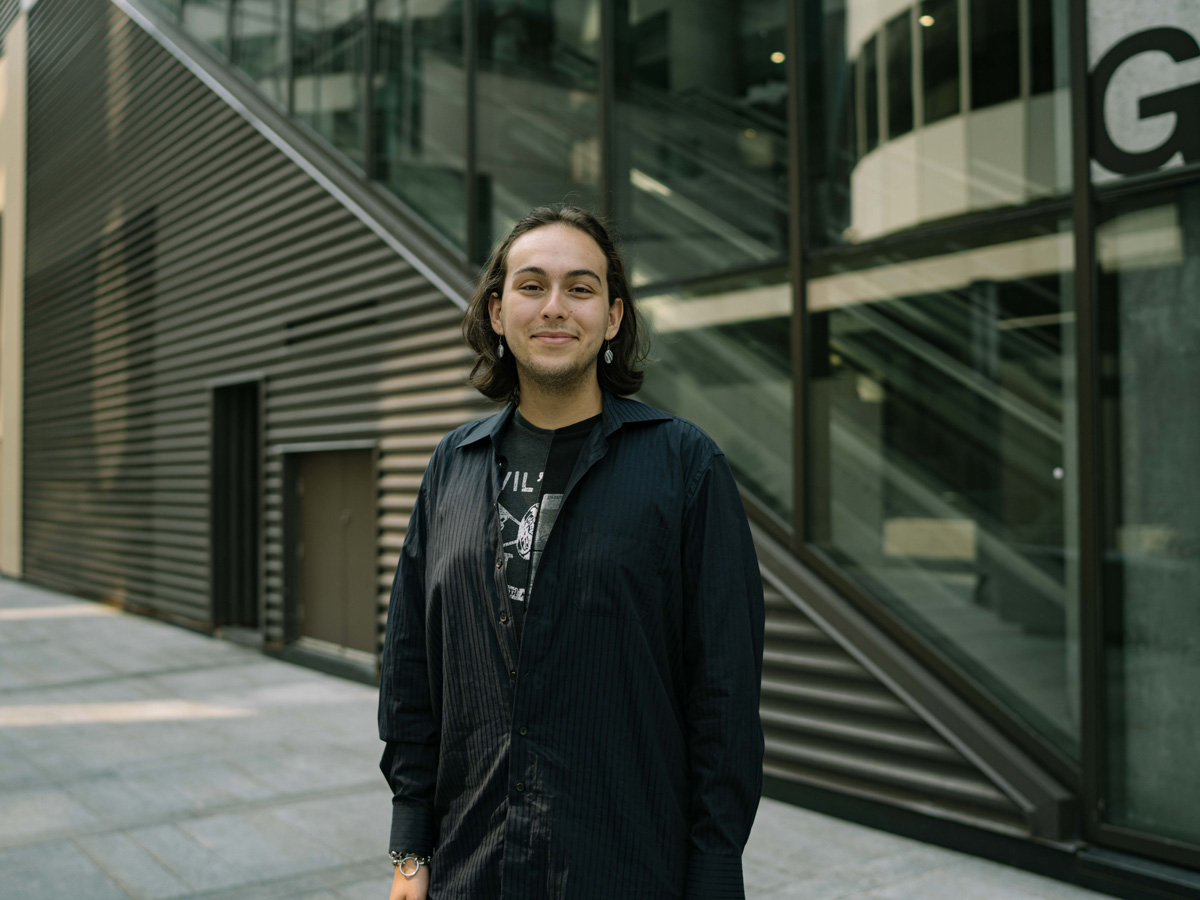 Paul Beniaminov, a Media Production student standing outside of the Ted Rogers School of Management (TRSM) building.