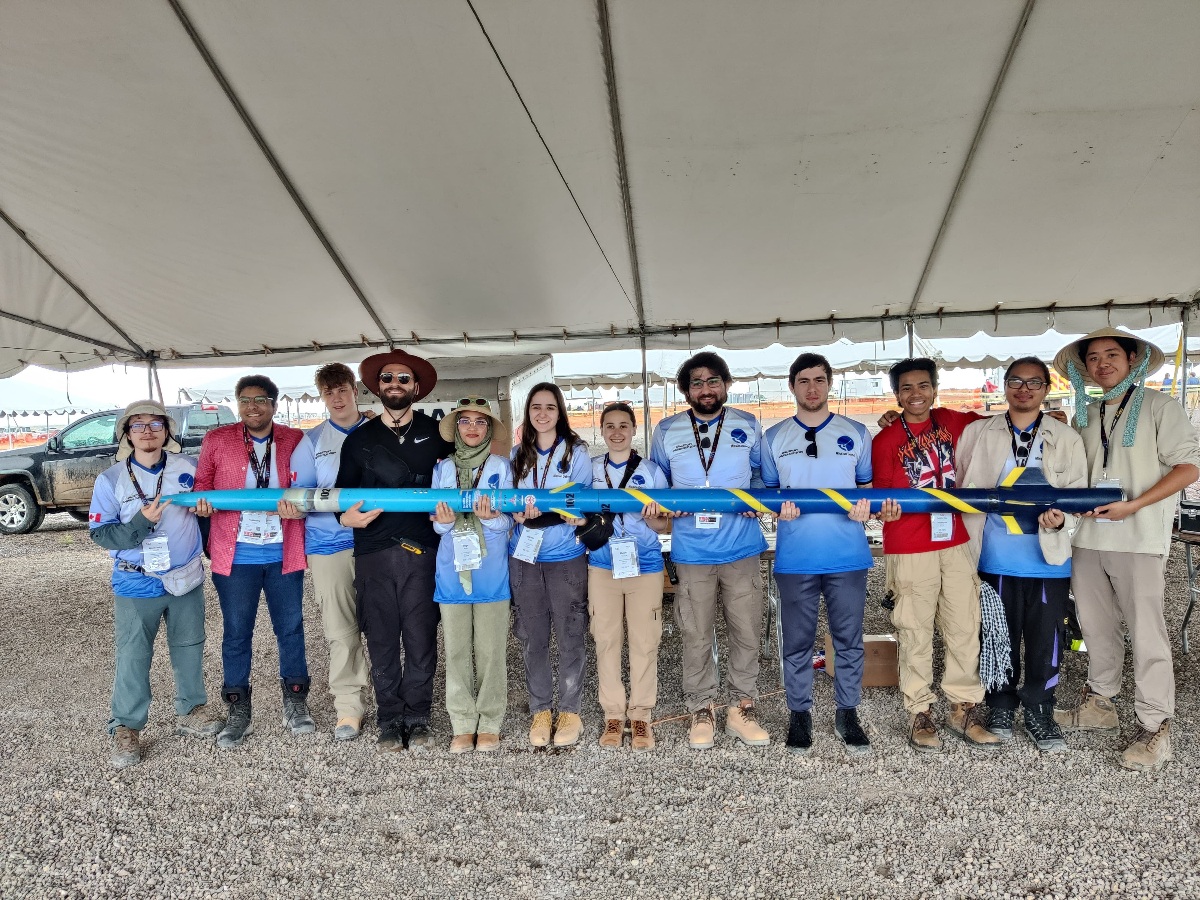In sandy New Mexico, Bao and 12 of his teammates proudly show off a long rocket they've built.