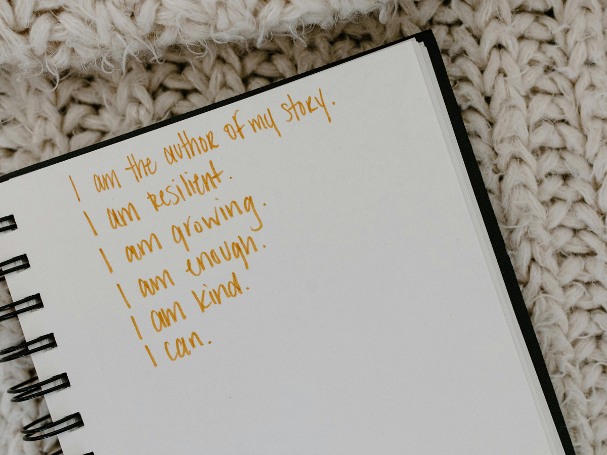 A list of positive affirmations written on a page of an open notebook.