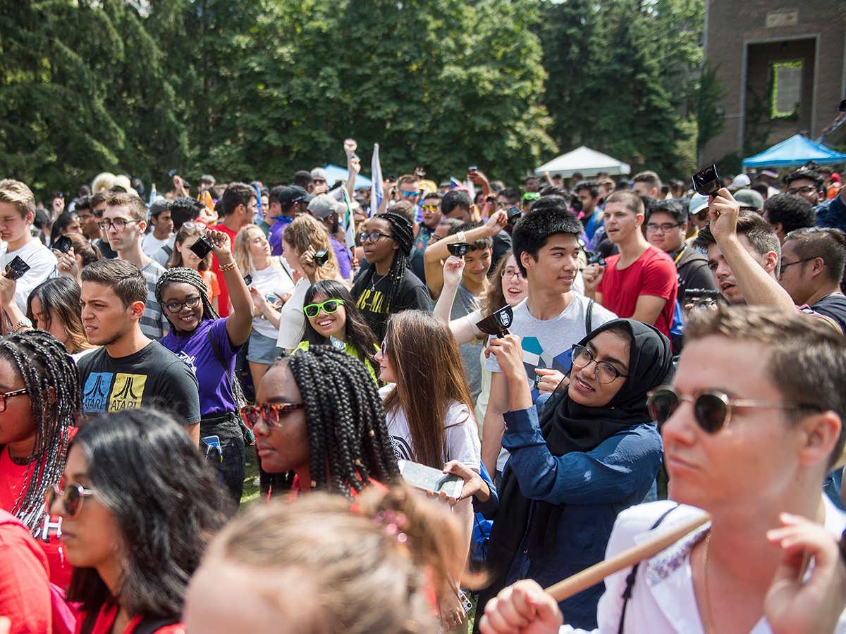 A crowd of new TMU students enjoying an outdoor Orientation event in the Quad on a sunny day.
