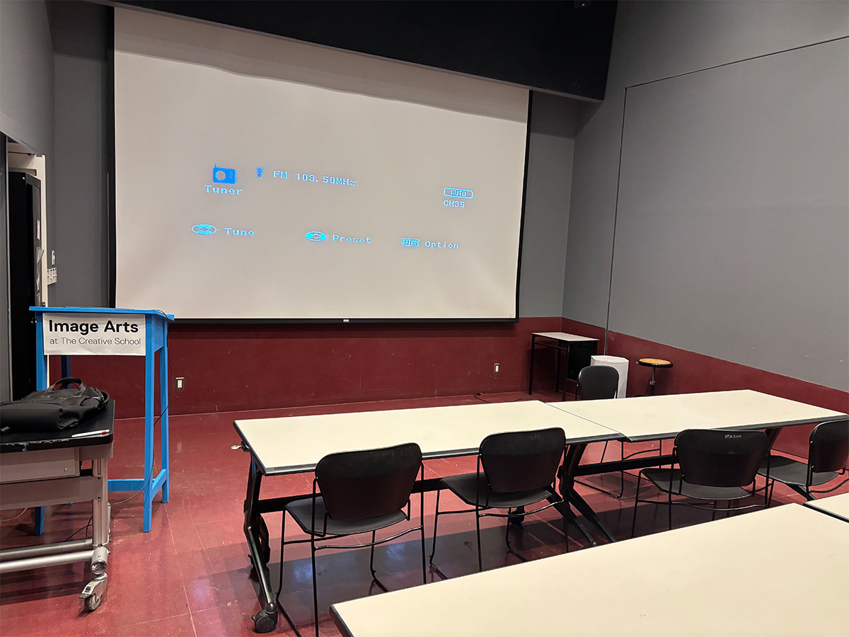 A lecture room with a projector screen inside the Image Arts building.