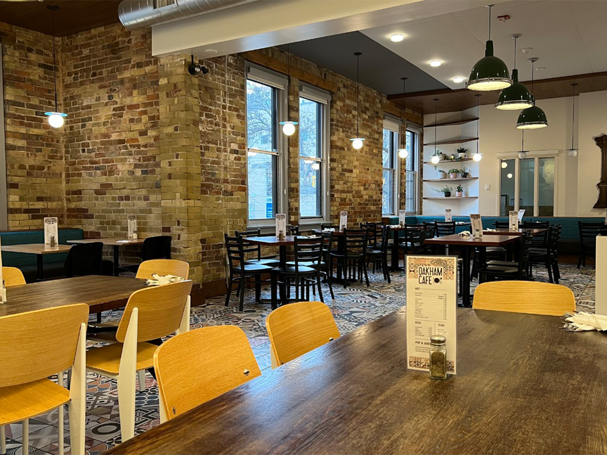 The wooden tables, exposed brick walls and mosaic tile floors of the Oakham Cafe restaurant.