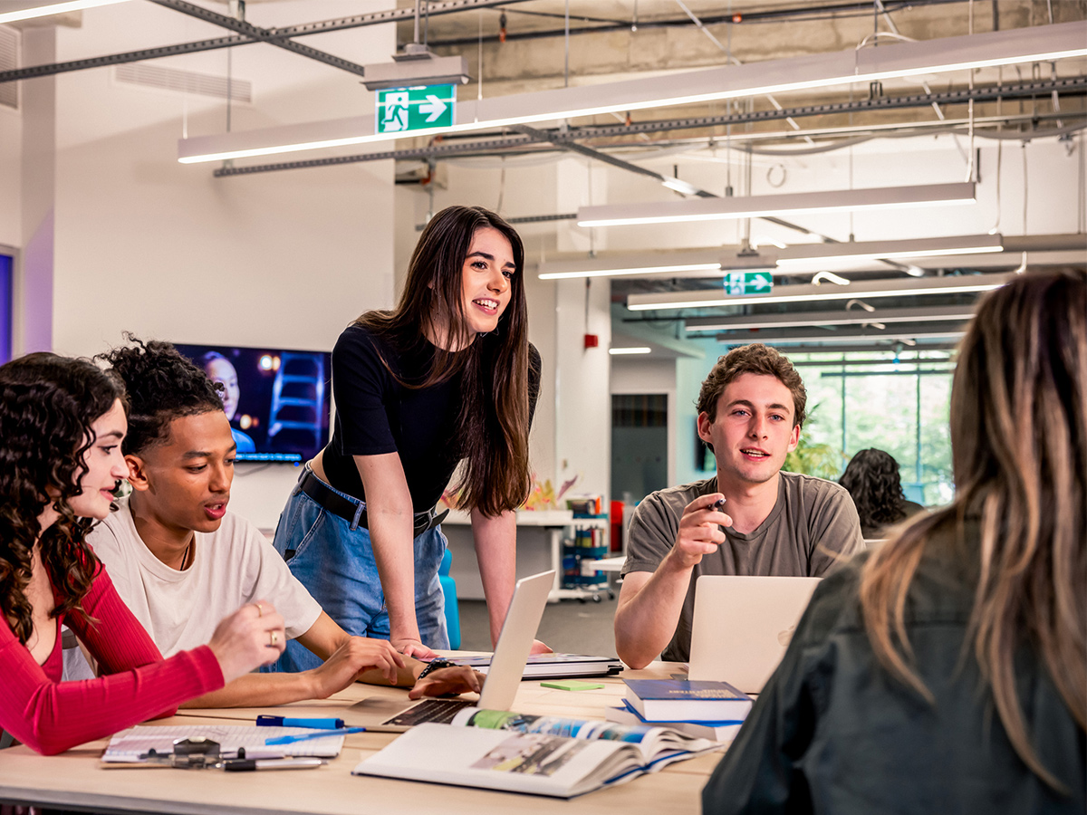 A group of students around a table collaborating on a project.