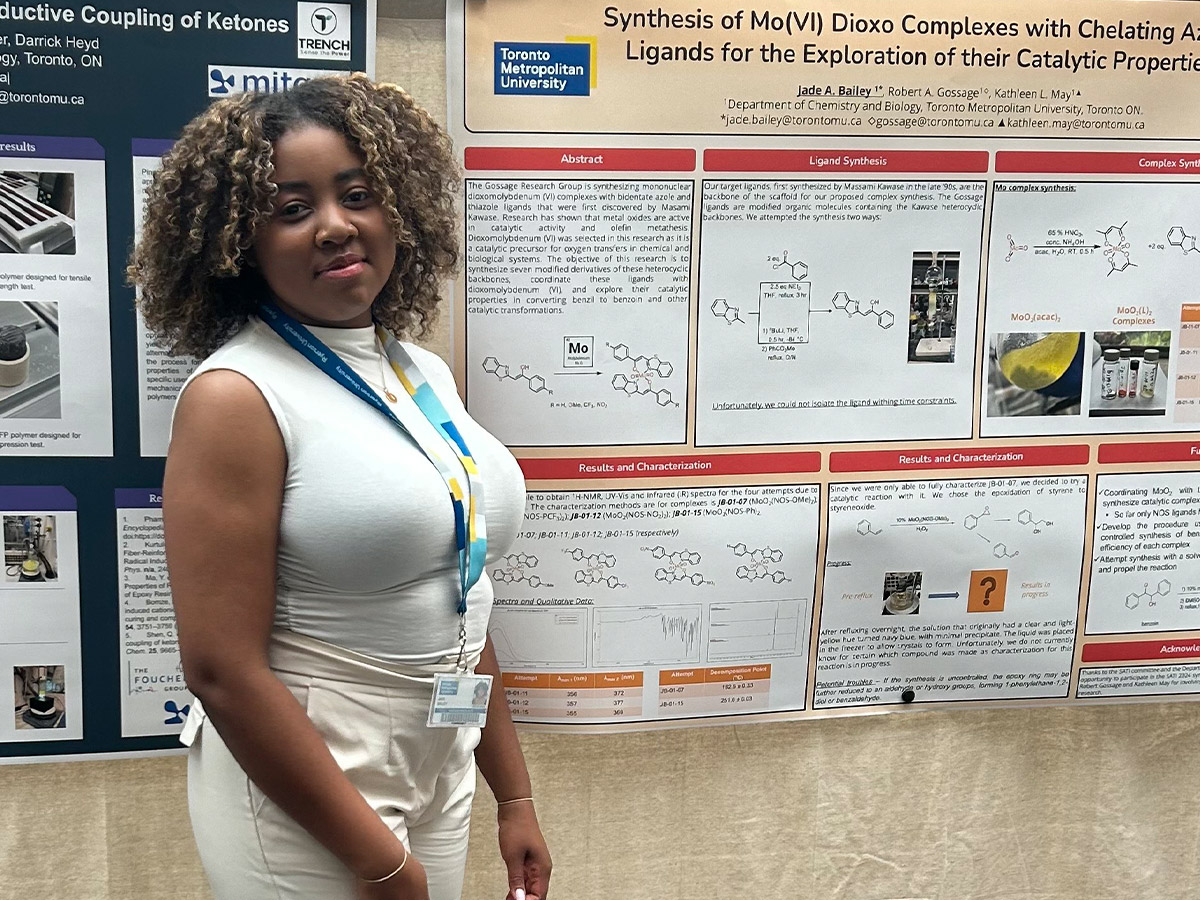 Jade poses in front of a banner project she completed for her Chemistry program.