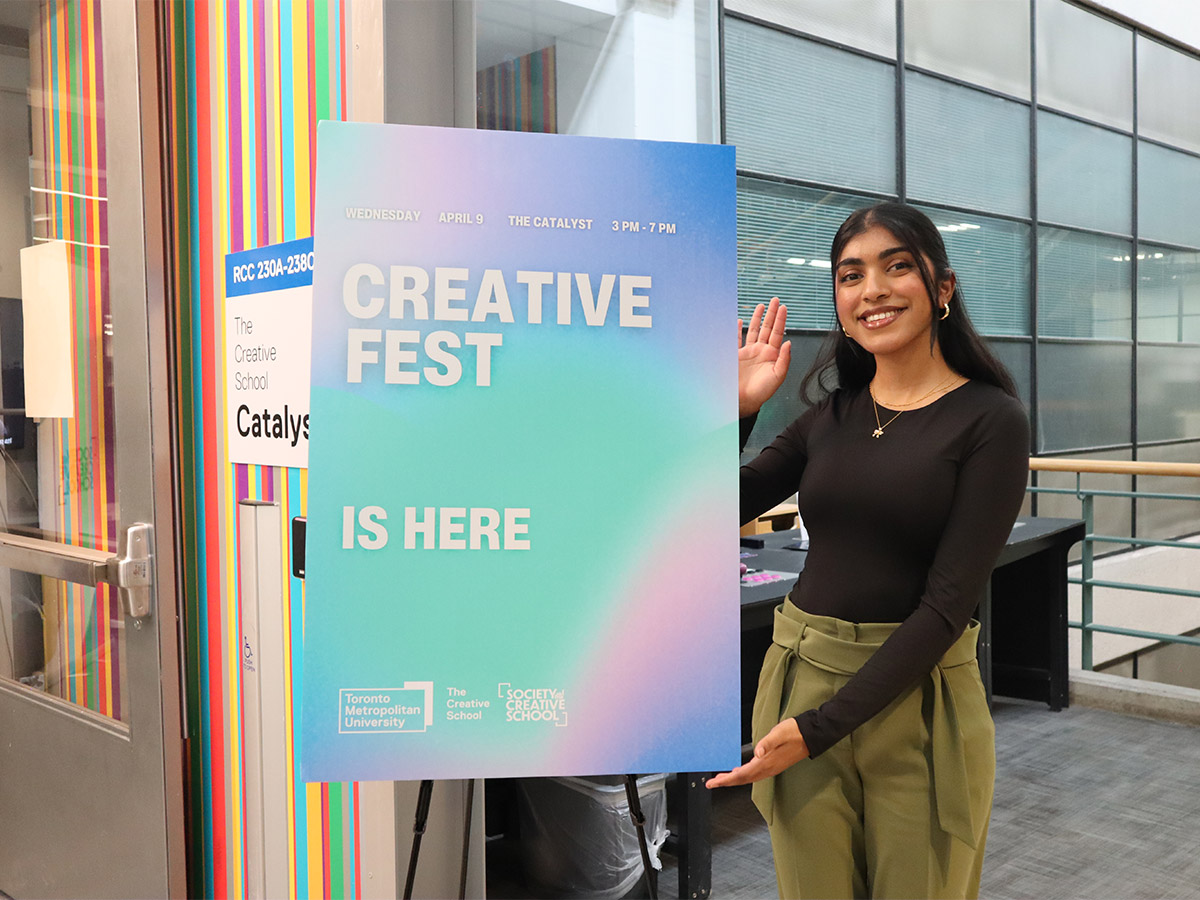 Vasaavi points to a sign advertising Creative Fest.