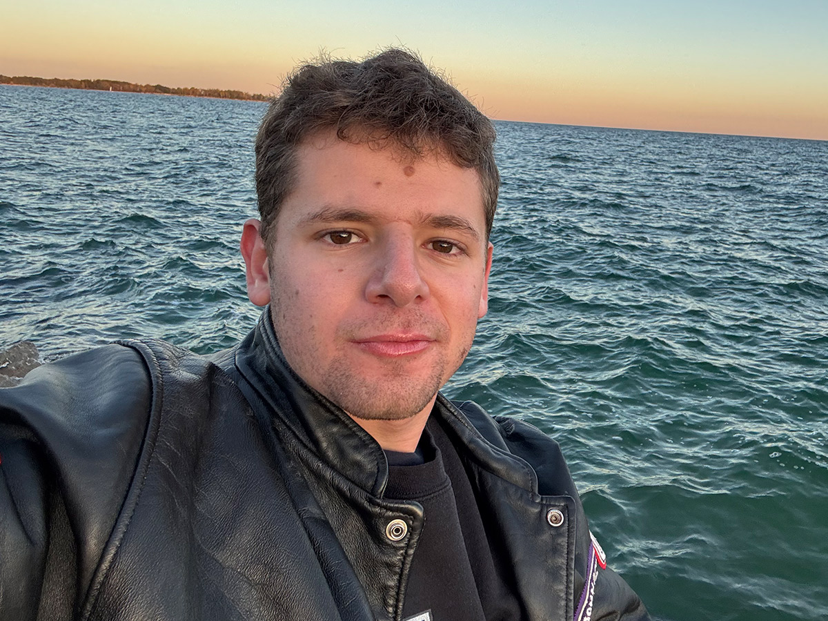 Ido takes a selfie in front of Lake Ontario during a sunset.