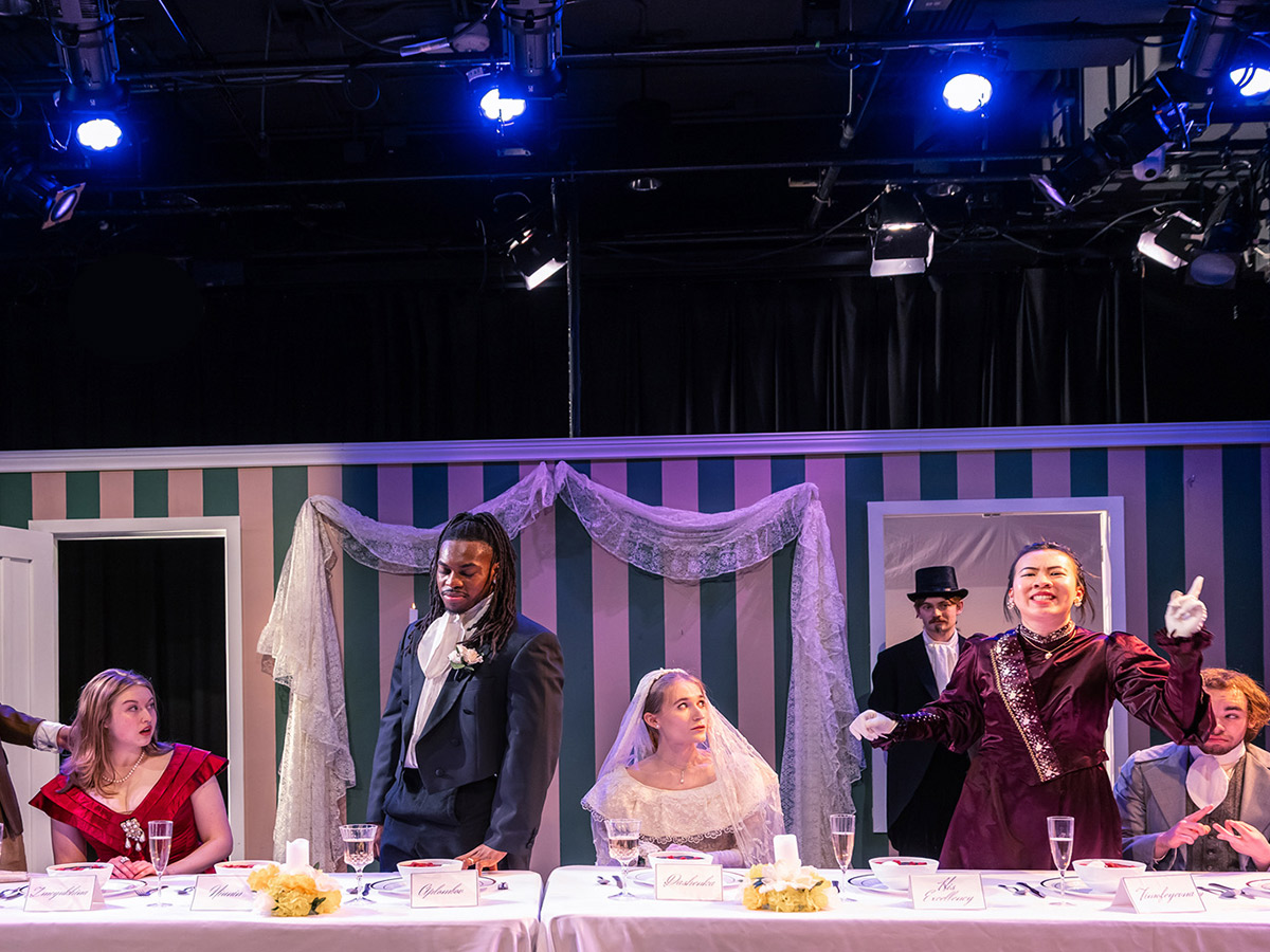 Students at the School of Performance act on stage wearing period costumes.