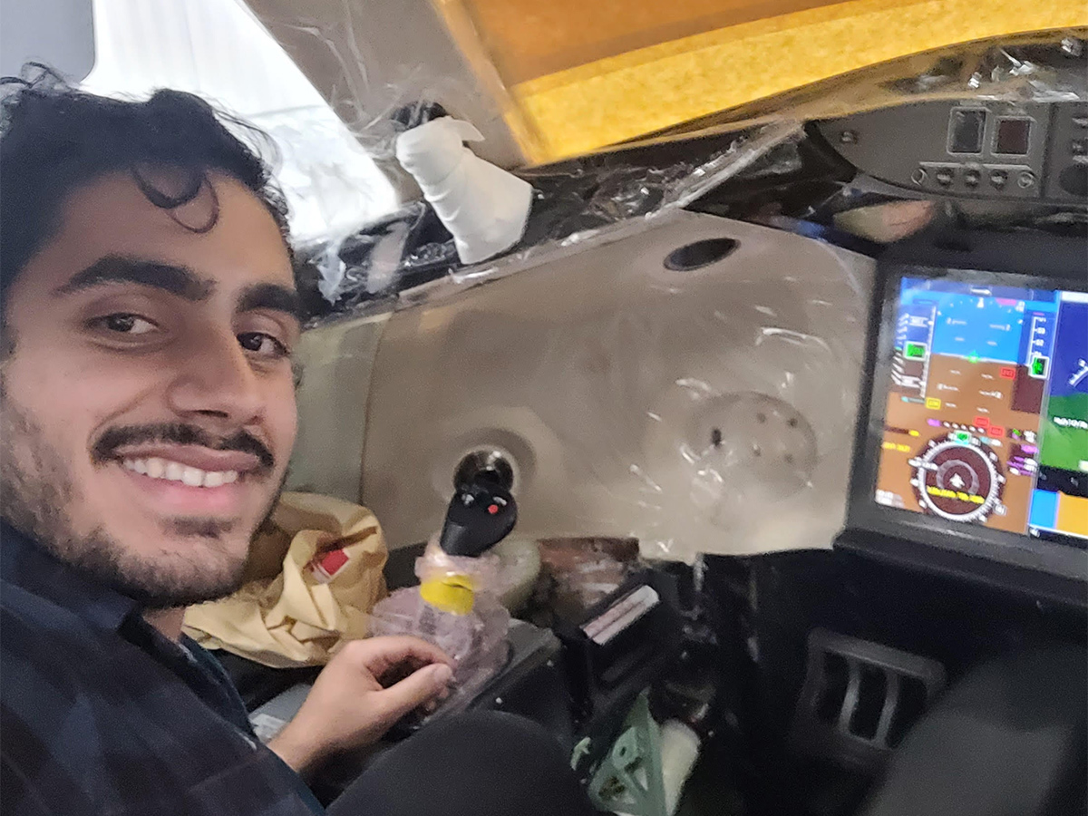Ahmed smiles inside the cockpit of a Global 7500 business jet.
