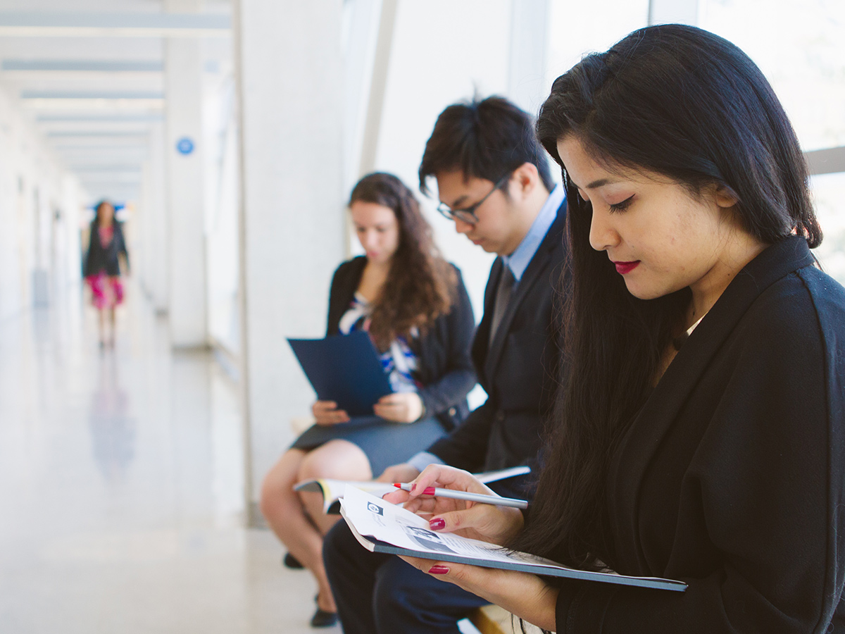 Candidates for a job wait in a hallway for their interview.