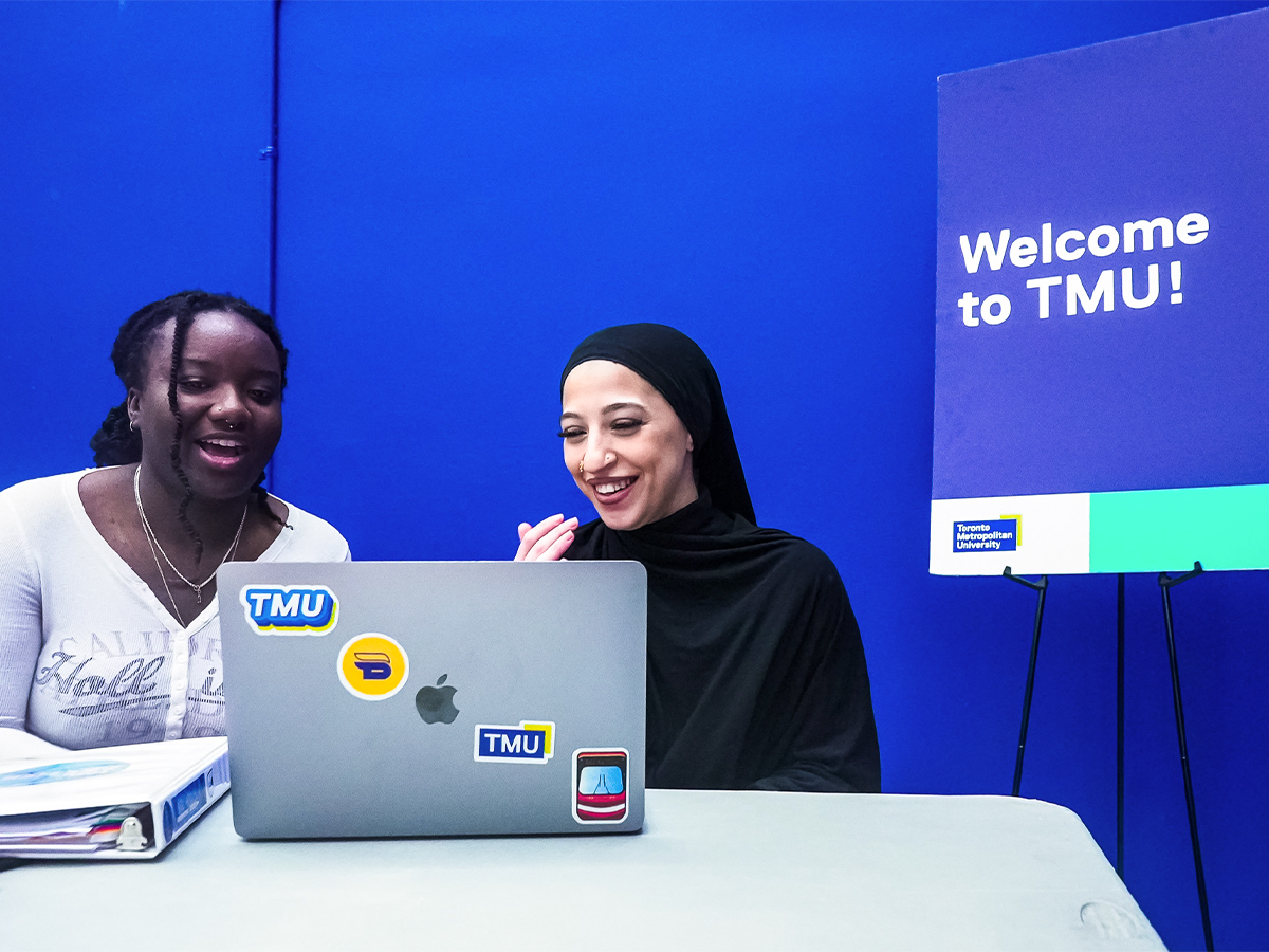 Ayia sits next to her Career Boost coworker at a recruitment event.