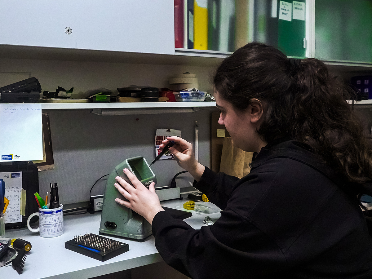 Morgan repairs a Moviscop 16mm film viewer.