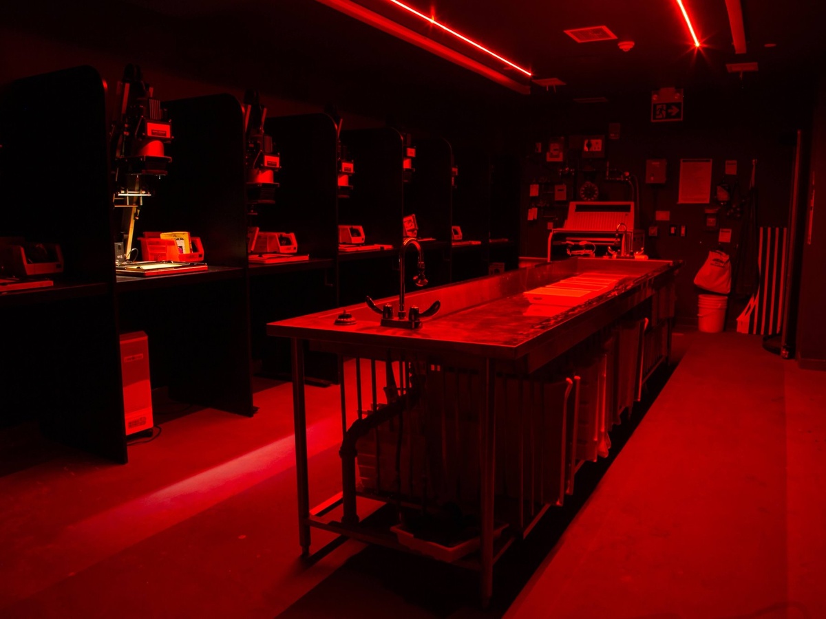 A red safelight illuminates the work stations of the primary analogue darkroom in the School of Image Arts.