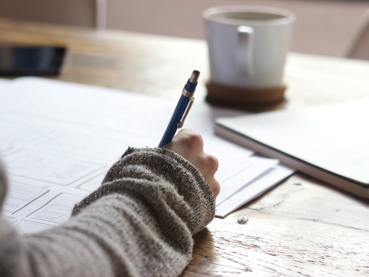 A writer puts pen to paper, sketching down ideas.