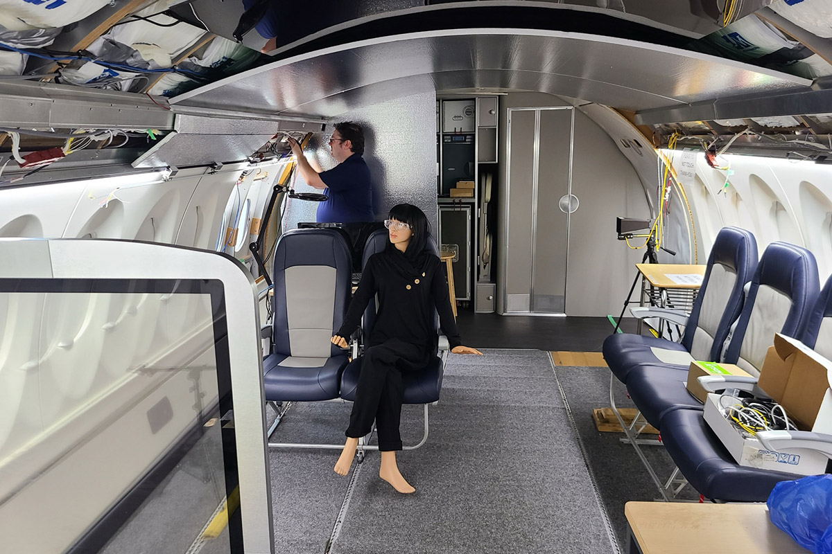 Two students practicing maintenance in the aircraft cabin simulator