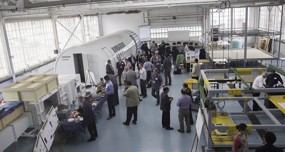 A group of researchers network in the Ryerson Aerospace Engineering Centre facility