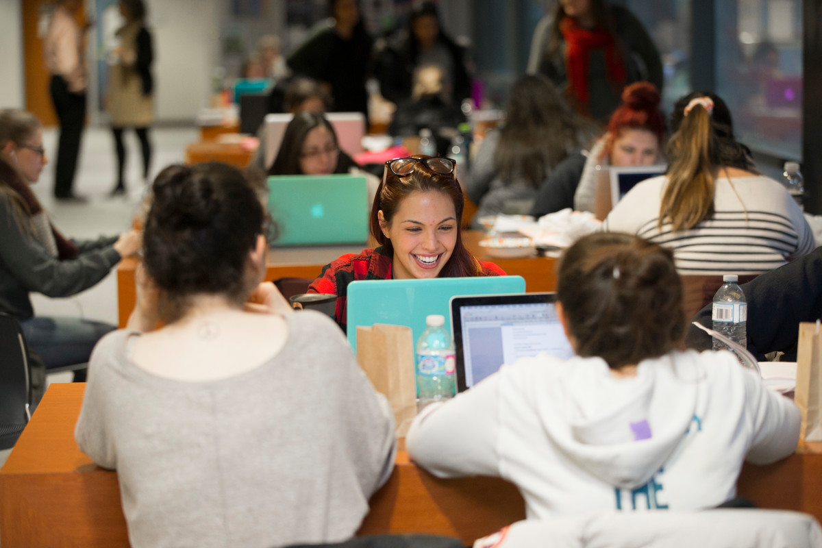 students studying on their laptops and laughing