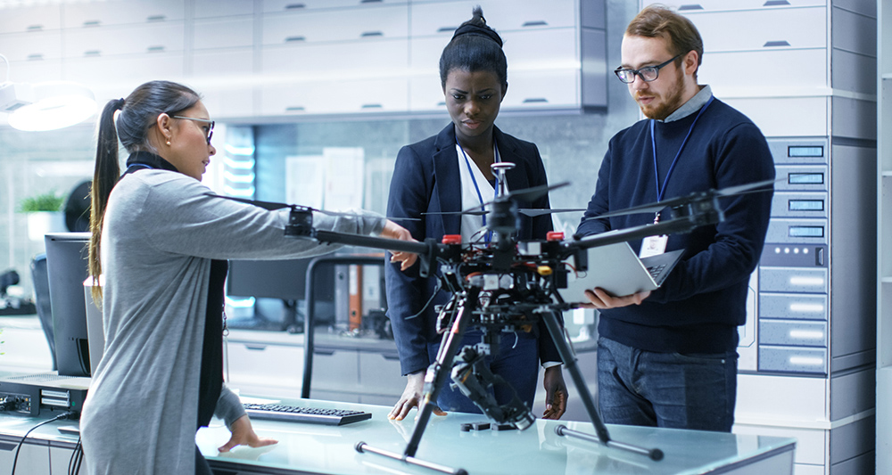 Three professional engineers working on a drone